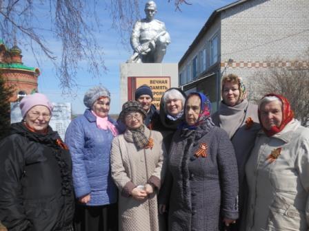 Участники вокальной группы ветеранов у памятника воинам, погибшим в годы Великой Отечественной войны